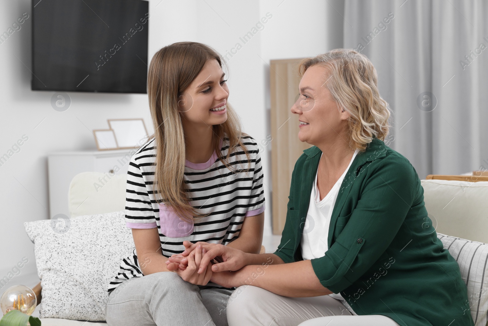 Photo of Young woman with her mom at home. Happy Mother's Day