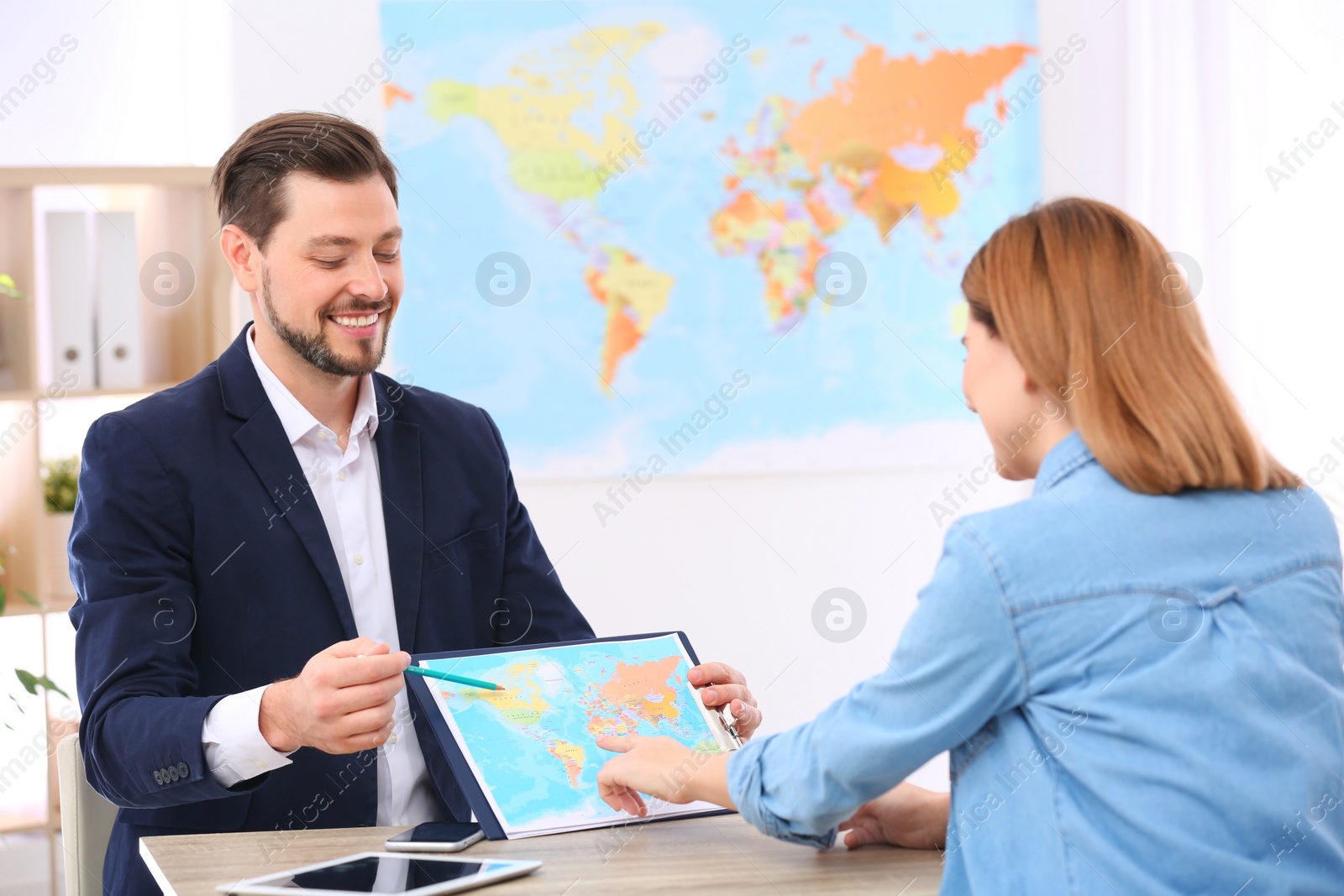 Photo of Male manager consulting client in travel agency