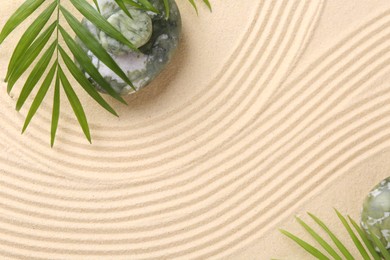 Photo of Zen concept. Stones, leaves and pattern on beige sand, flat lay. Space for text