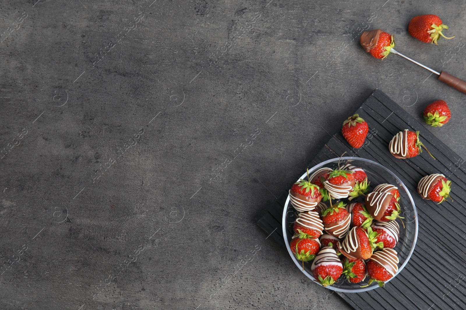 Photo of Flat lay composition with chocolate covered strawberries on grey background