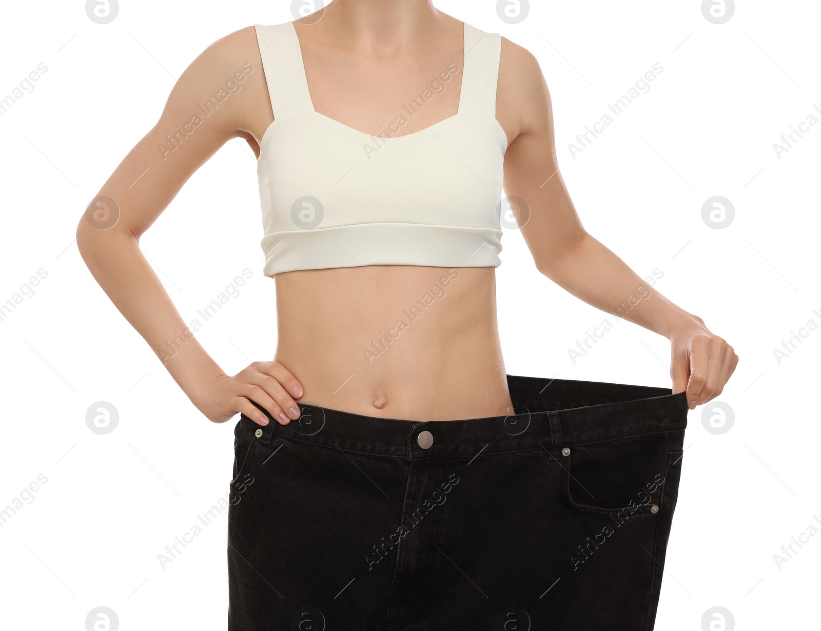 Photo of Young woman wearing big jeans after weight loss on white background, closeup