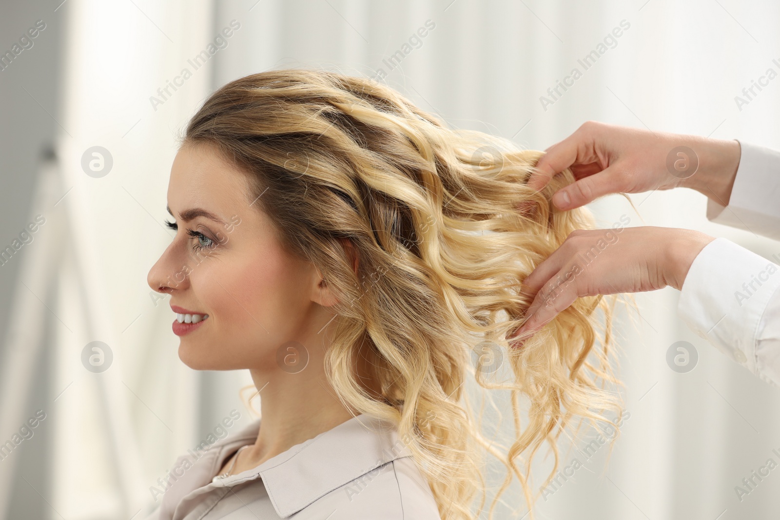 Photo of Hair styling. Professional hairdresser working with smiling client indoors, closeup