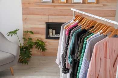 Wardrobe rack with stylish clothes in dressing room