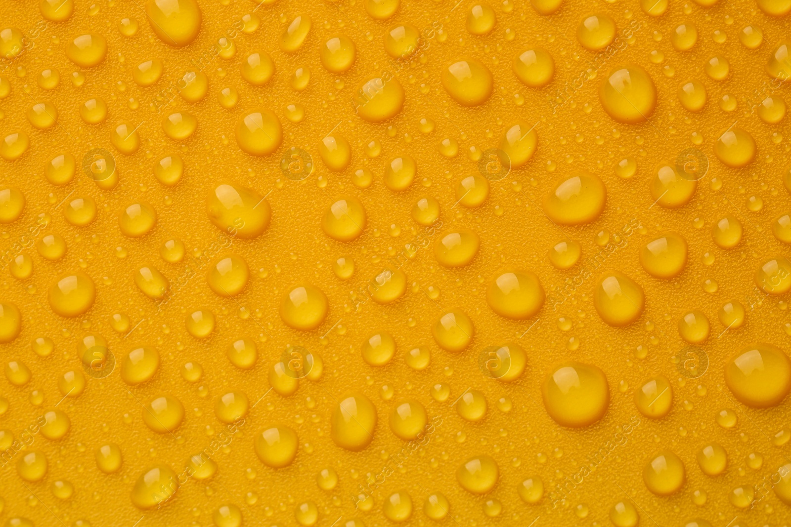 Photo of Water drops on orange background, top view