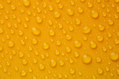 Photo of Water drops on orange background, top view