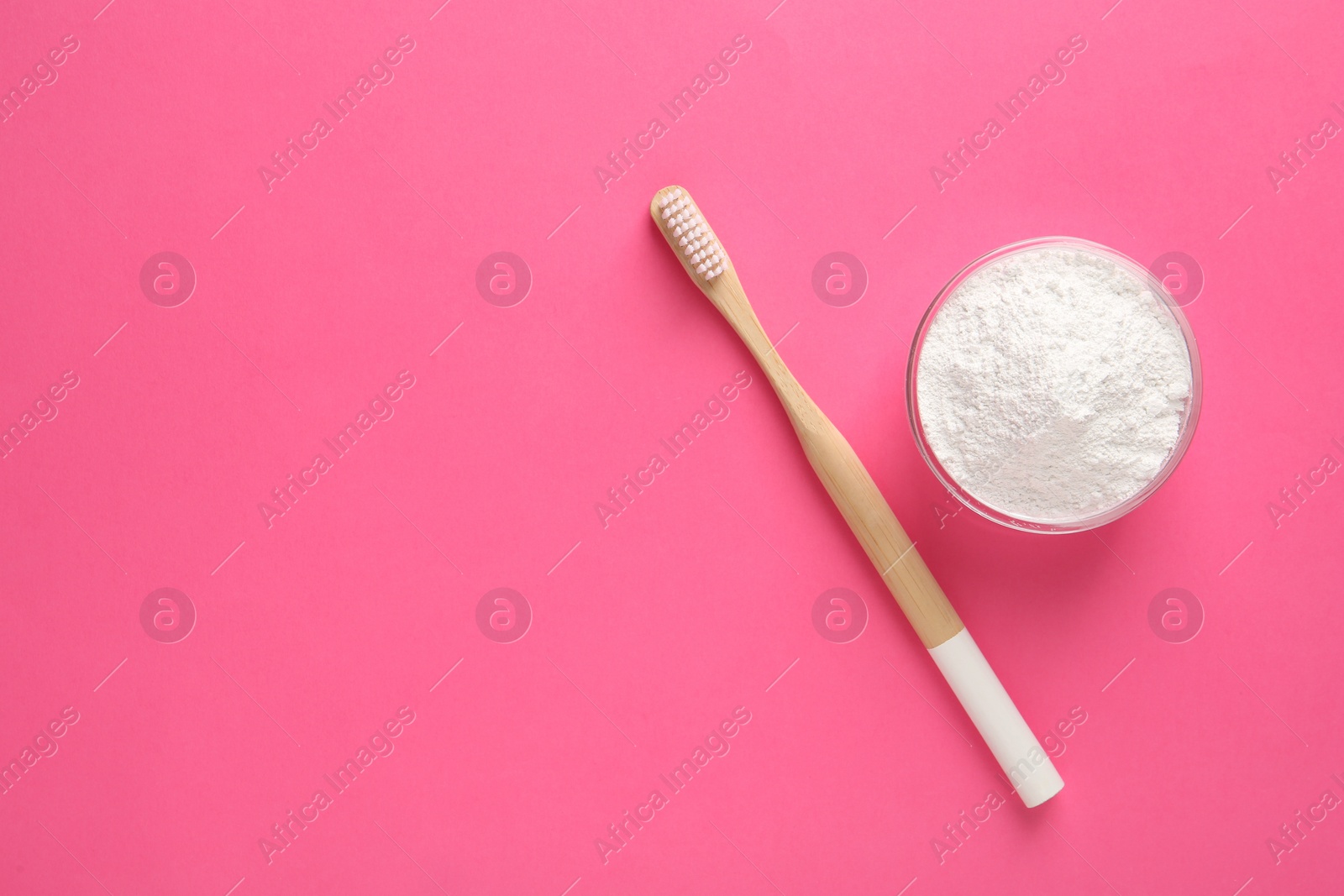 Photo of Bowl of tooth powder and brush on pink background, flat lay. Space for text