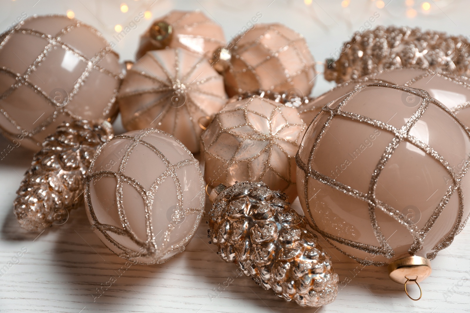 Photo of Collection of beautiful Christmas tree baubles on white wooden table, closeup