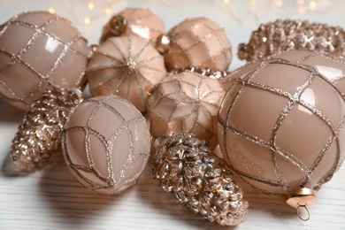 Photo of Collection of beautiful Christmas tree baubles on white wooden table, closeup