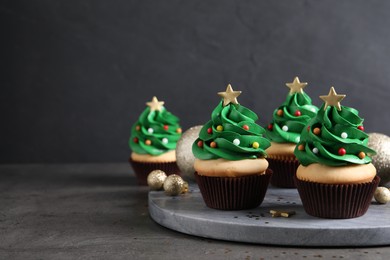 Photo of Christmas tree shaped cupcakes on grey table