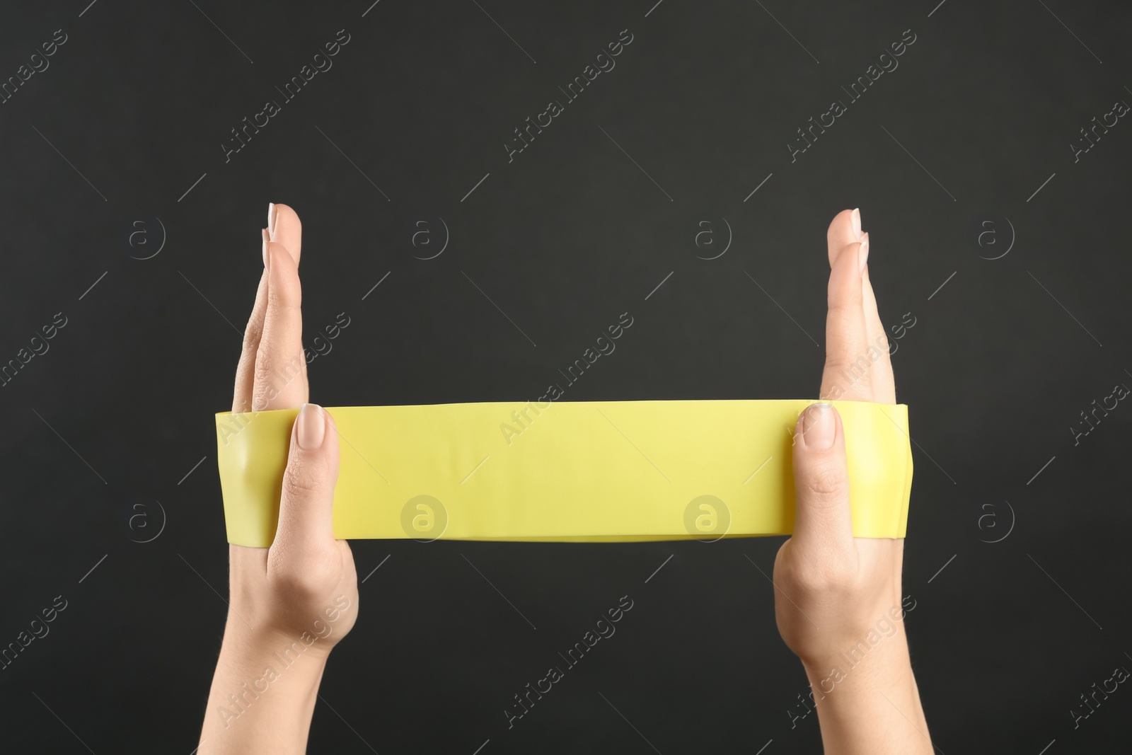 Photo of Woman with fitness elastic band on black background, closeup