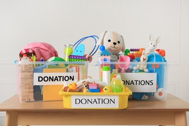 Donation boxes with different child toys on wooden table