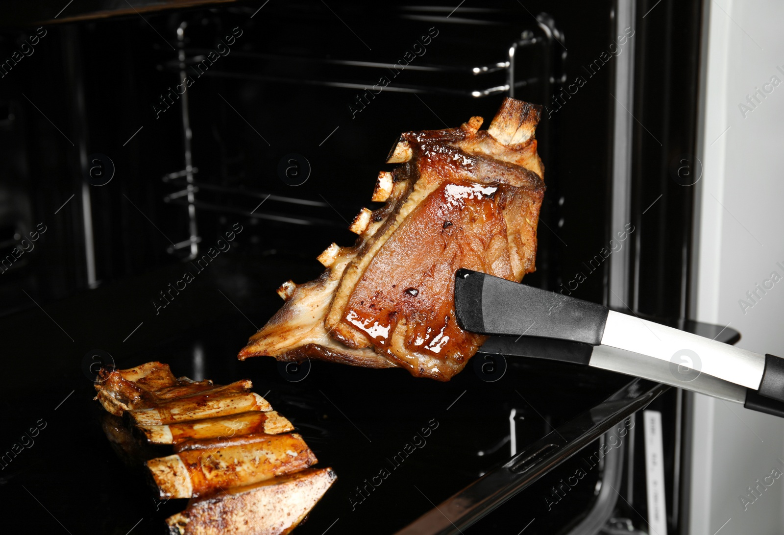 Photo of Delicious roasted ribs in oven. Yummy meat