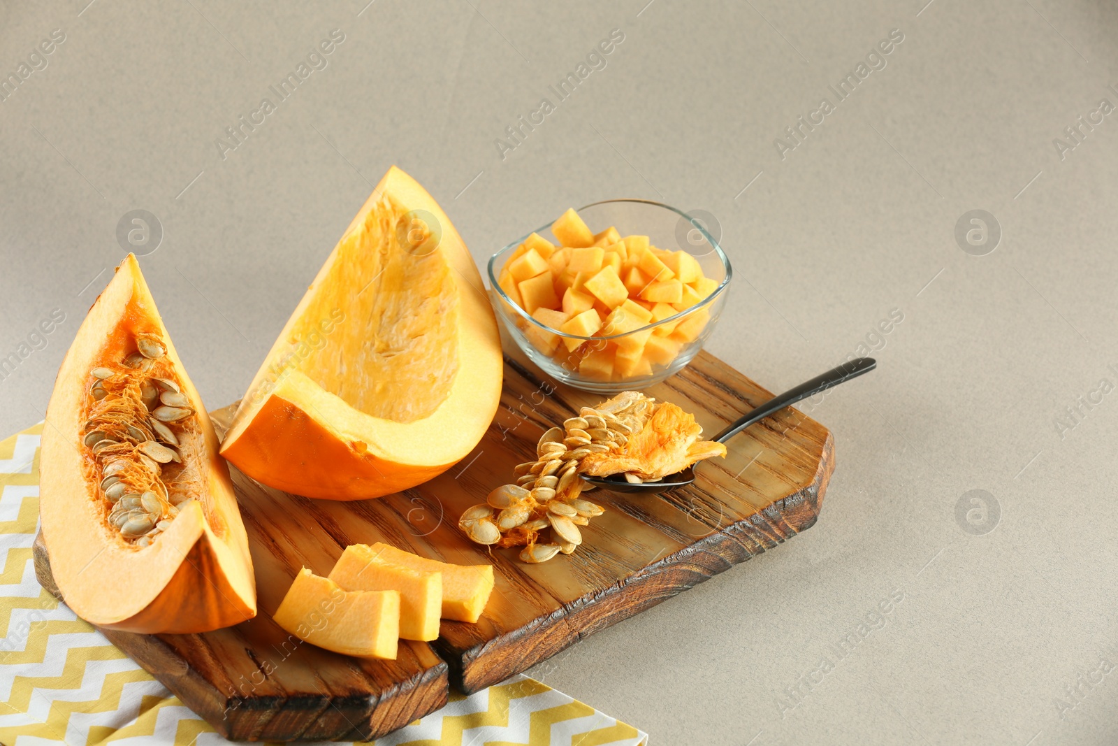 Photo of Cut fresh ripe pumpkin on grey background, space for text