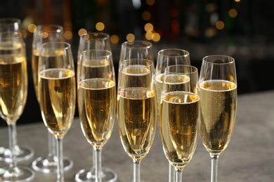 Photo of Glasses of champagne on table against blurred background