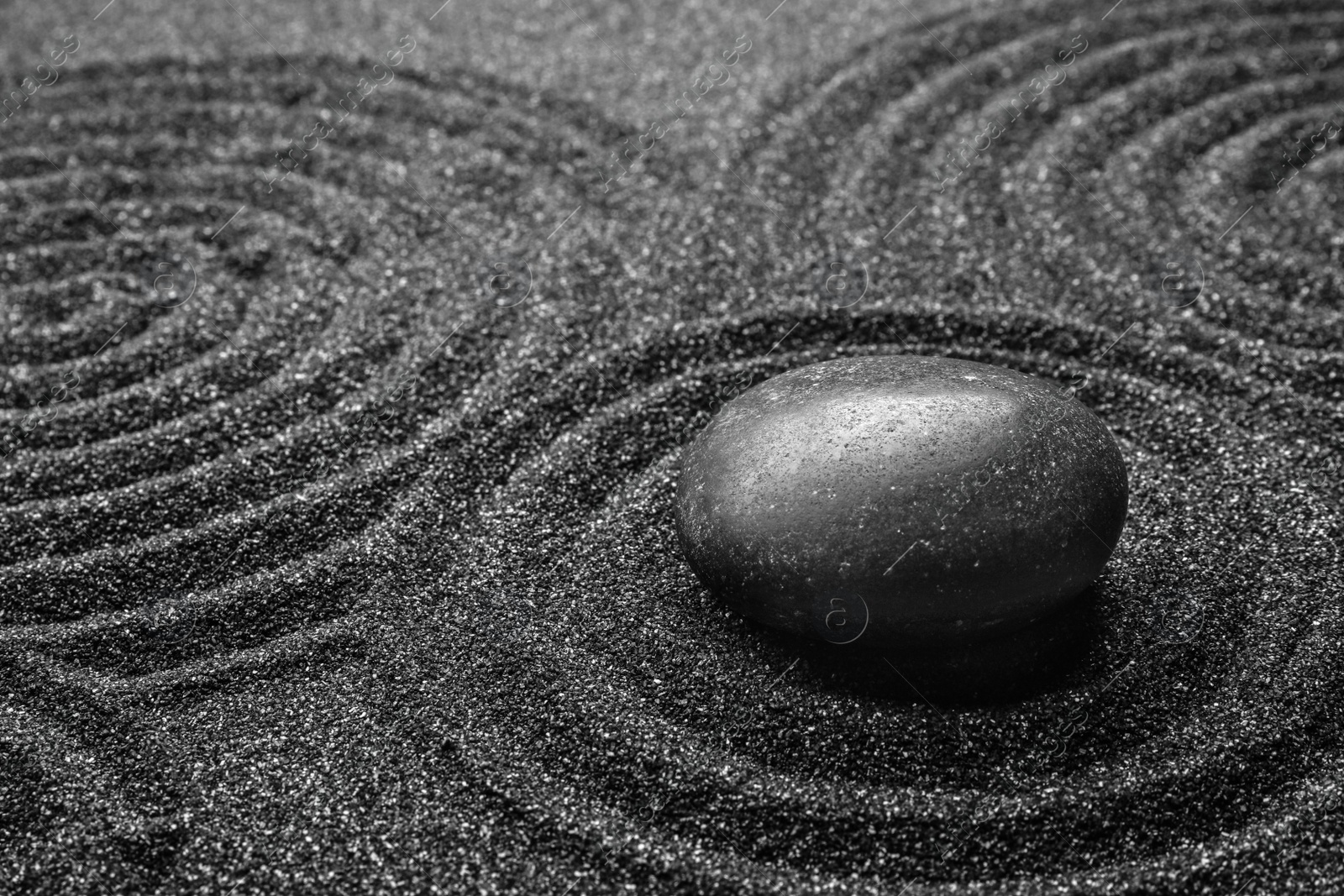 Photo of Black sand with stone and beautiful pattern. Zen concept