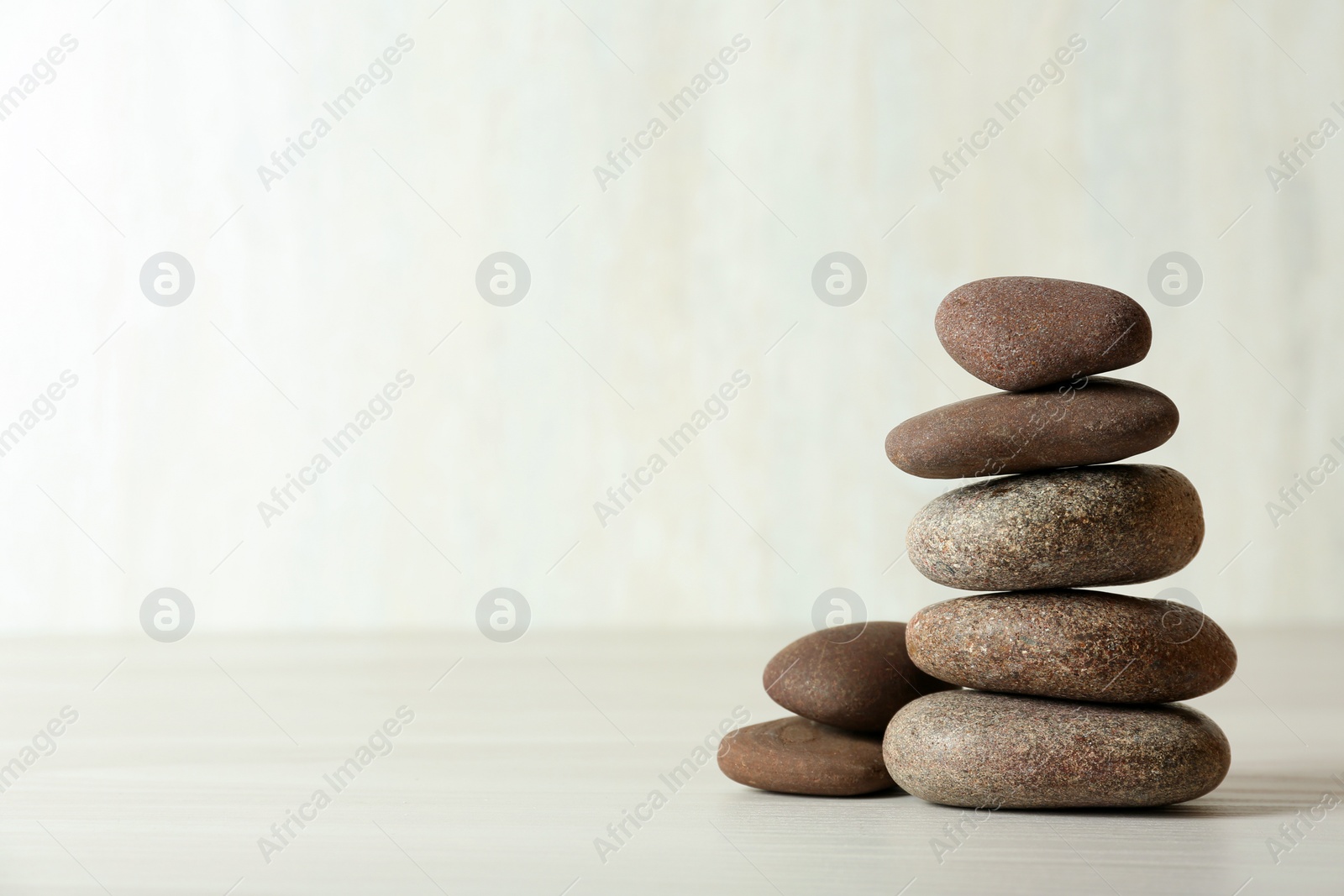 Photo of Stack of spa stones on table against white background, space for text