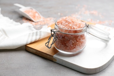 Pink himalayan salt in glass jar on grey table
