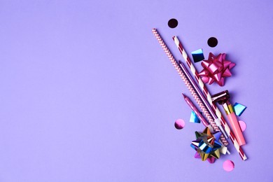 Party blower, colorful confetti and other festive decor on violet background, flat lay. Space for text