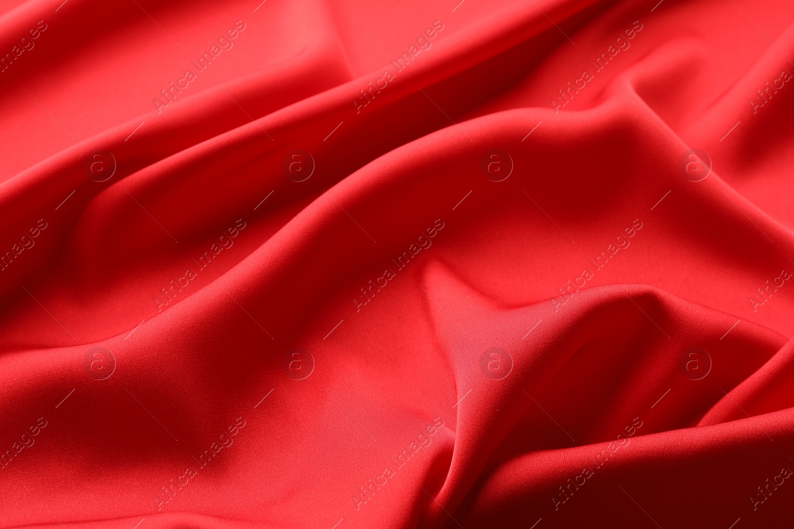 Photo of Crumpled red silk fabric as background, closeup