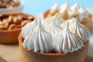 Tartlet with meringue on wooden board, closeup. Delicious dessert