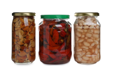 Glass jars of different pickled vegetables isolated on white