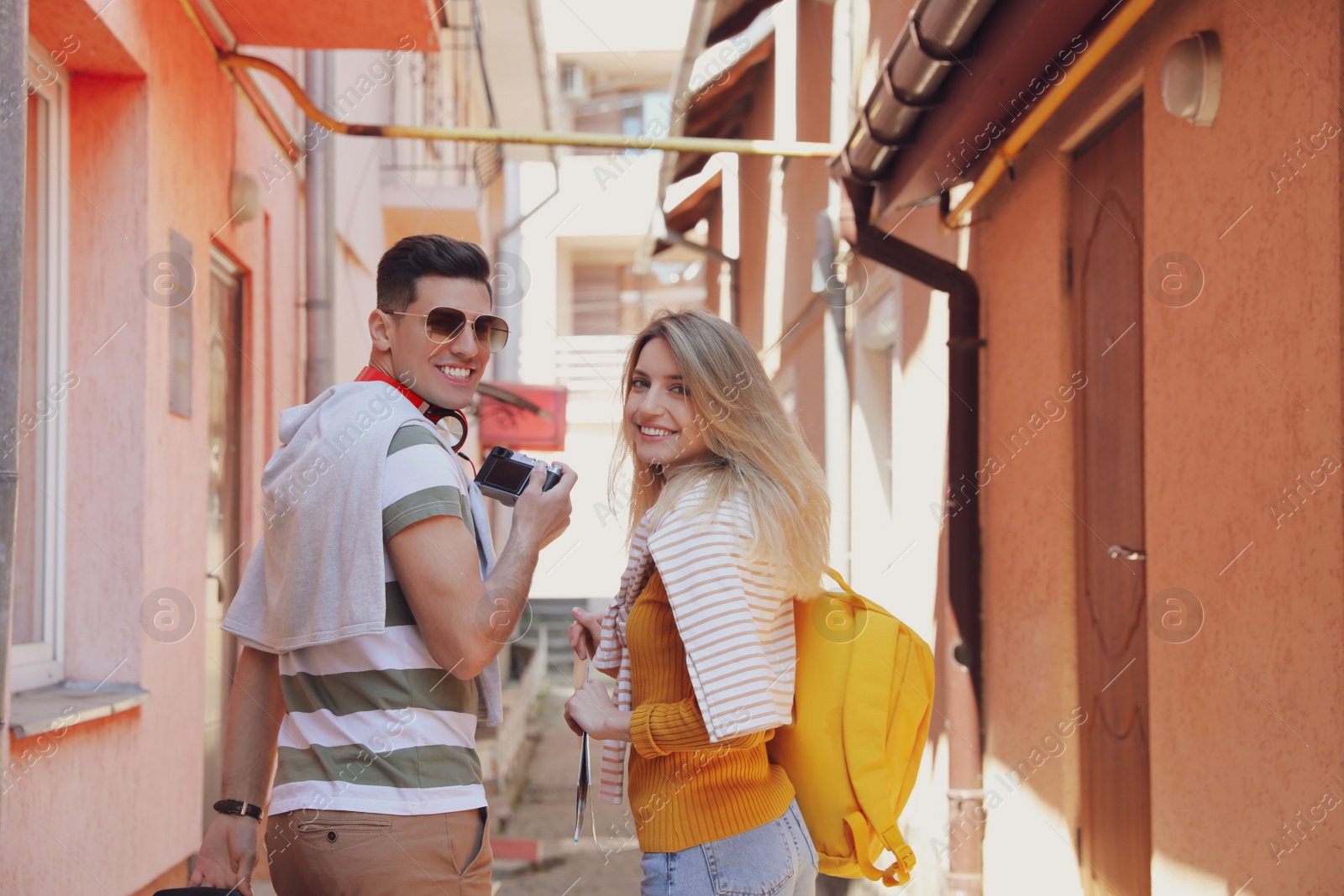 Photo of Couple of tourists walking on city street