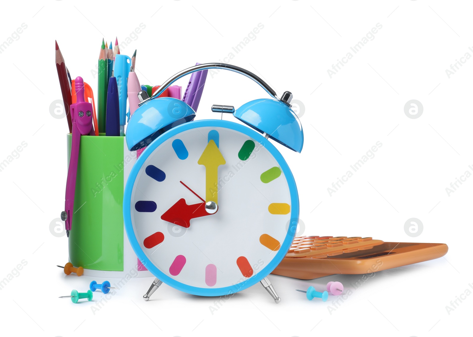 Photo of Light blue alarm clock and different stationery on white background. School time