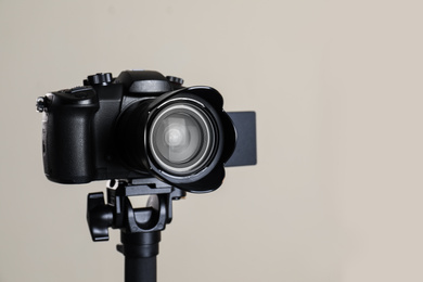 Photo of Modern professional video camera on beige background