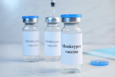 Monkeypox vaccine in glass vials on white wooden table