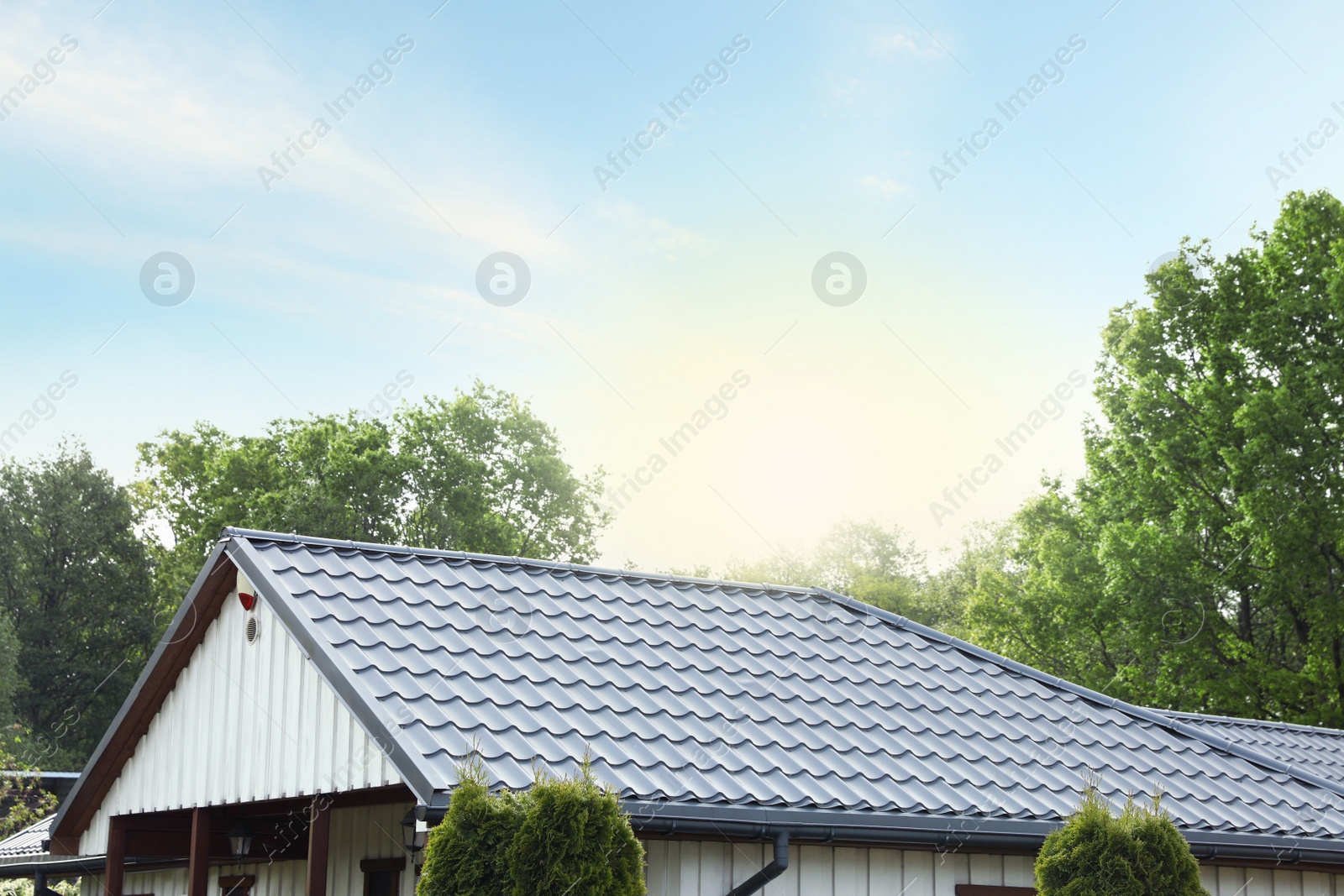 Photo of Modern building with grey roof outdoors on sunny day