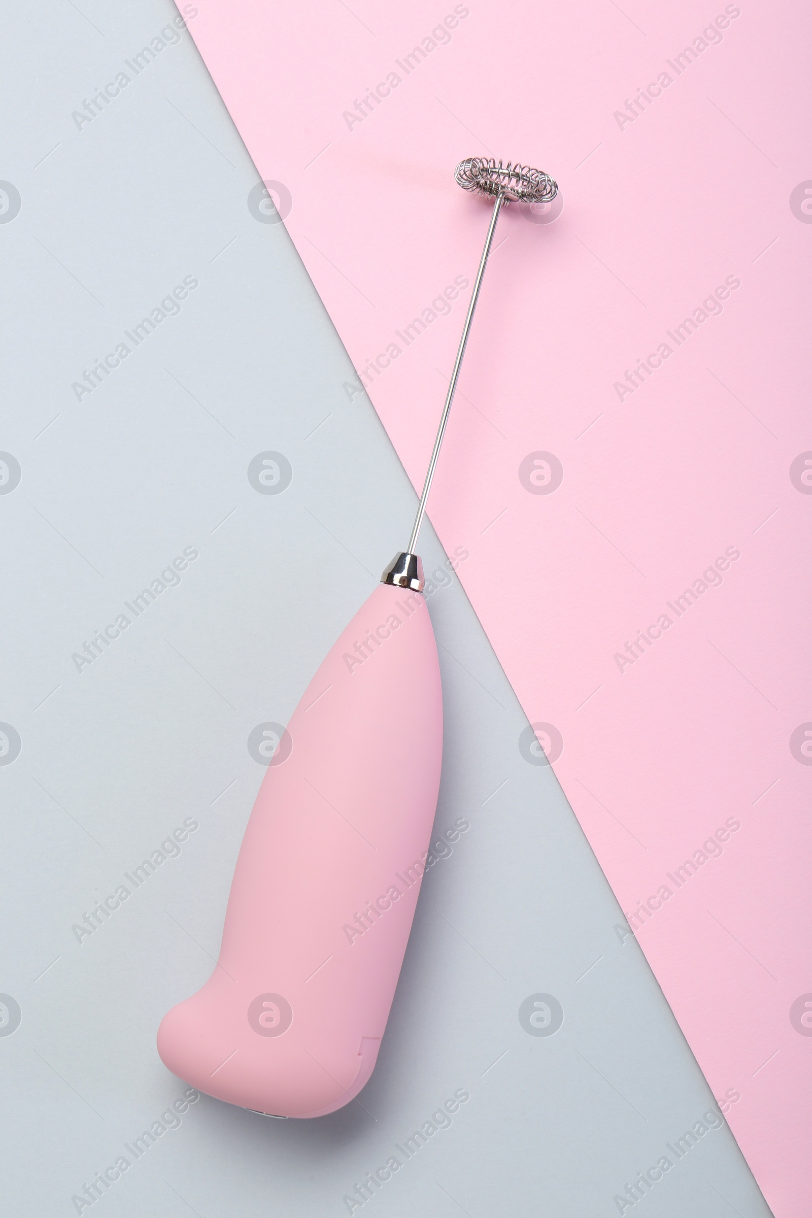 Photo of Pink milk frother wand on color background, top view