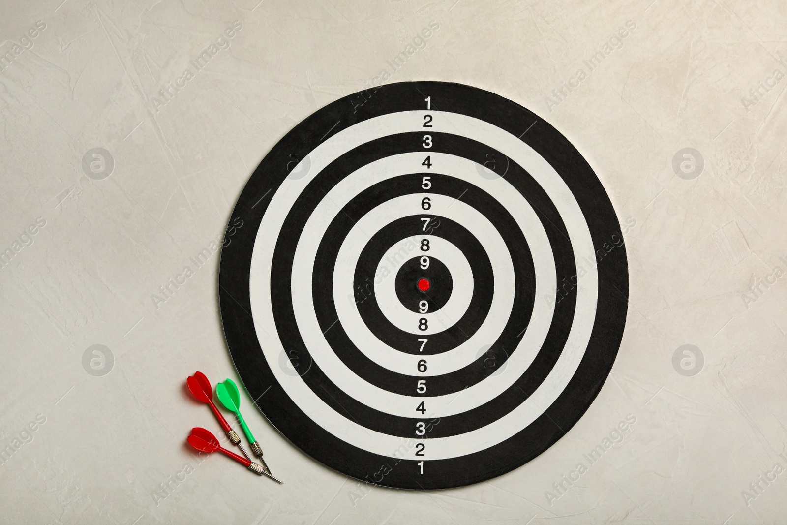 Photo of Dart board with color arrows on light stone background, top view