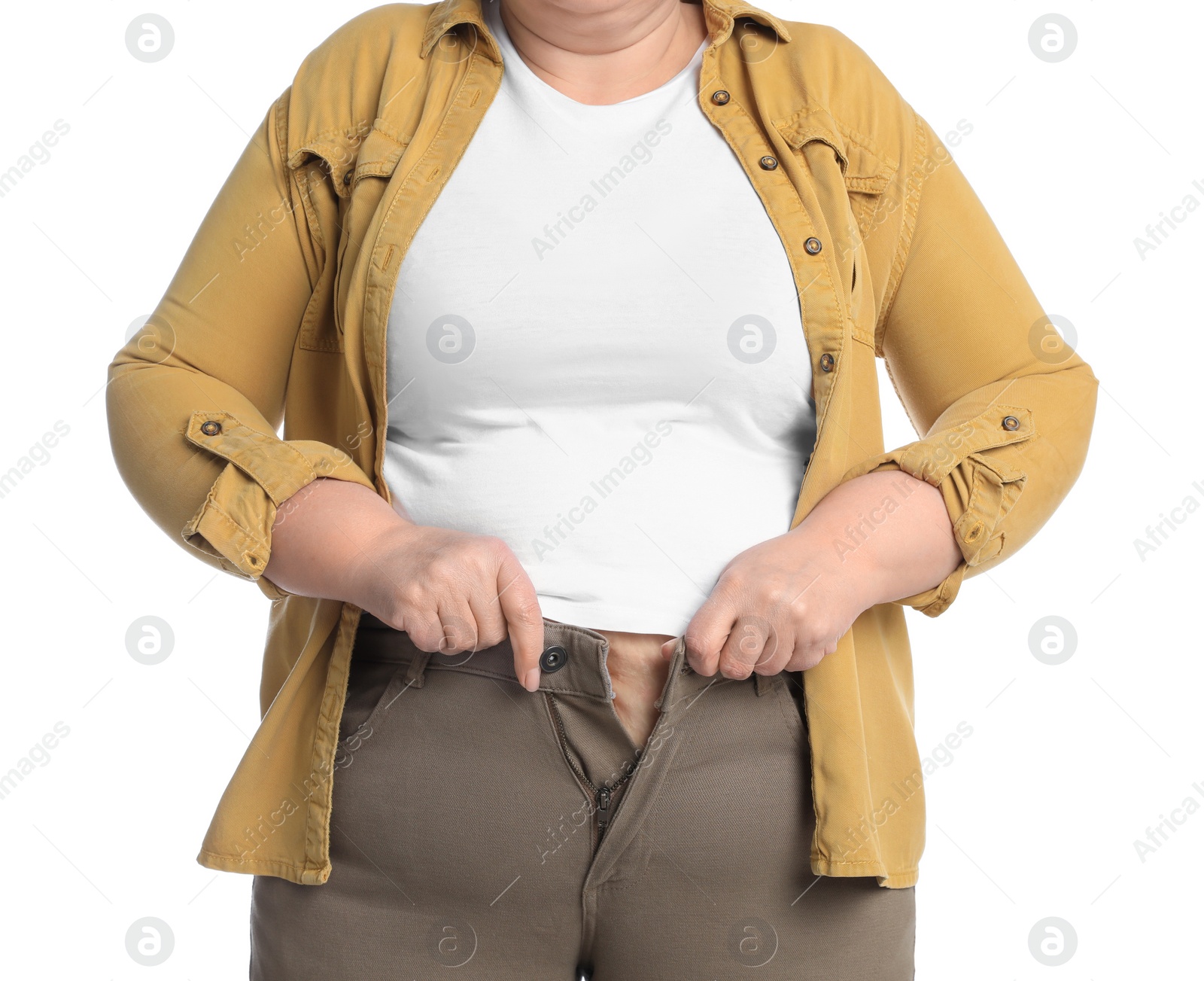 Photo of Overweight woman trying to button up tight trousers on white background, closeup