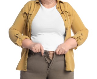 Overweight woman trying to button up tight trousers on white background, closeup