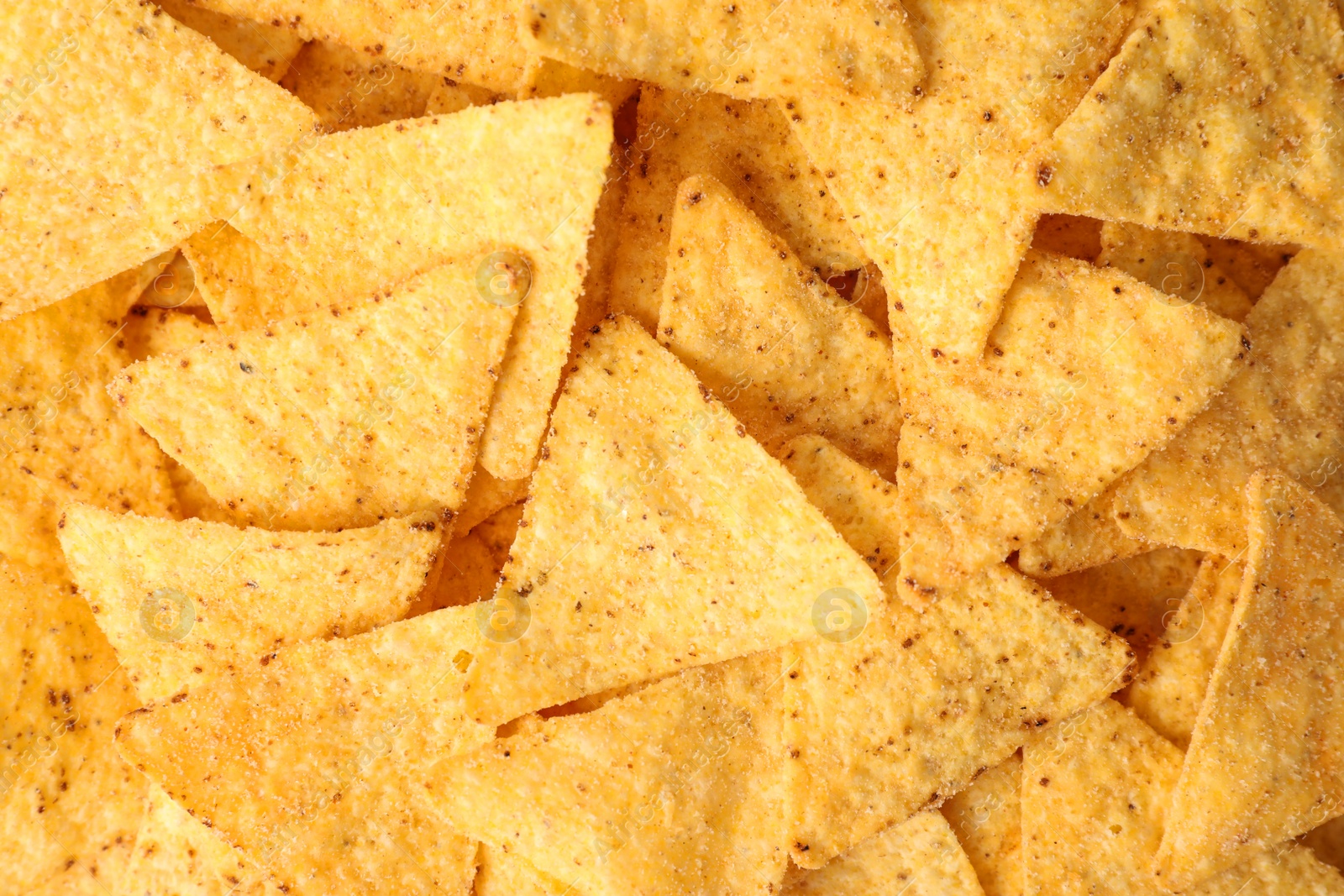 Photo of Tasty Mexican nachos chips as background, top view