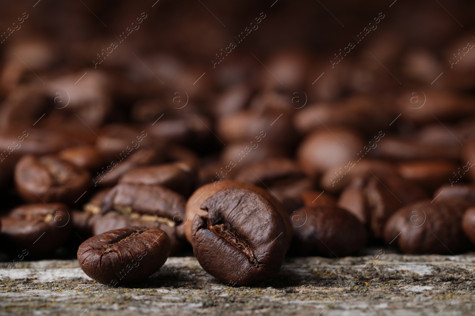 Photo of Many roasted coffee beans on wooden table, closeup