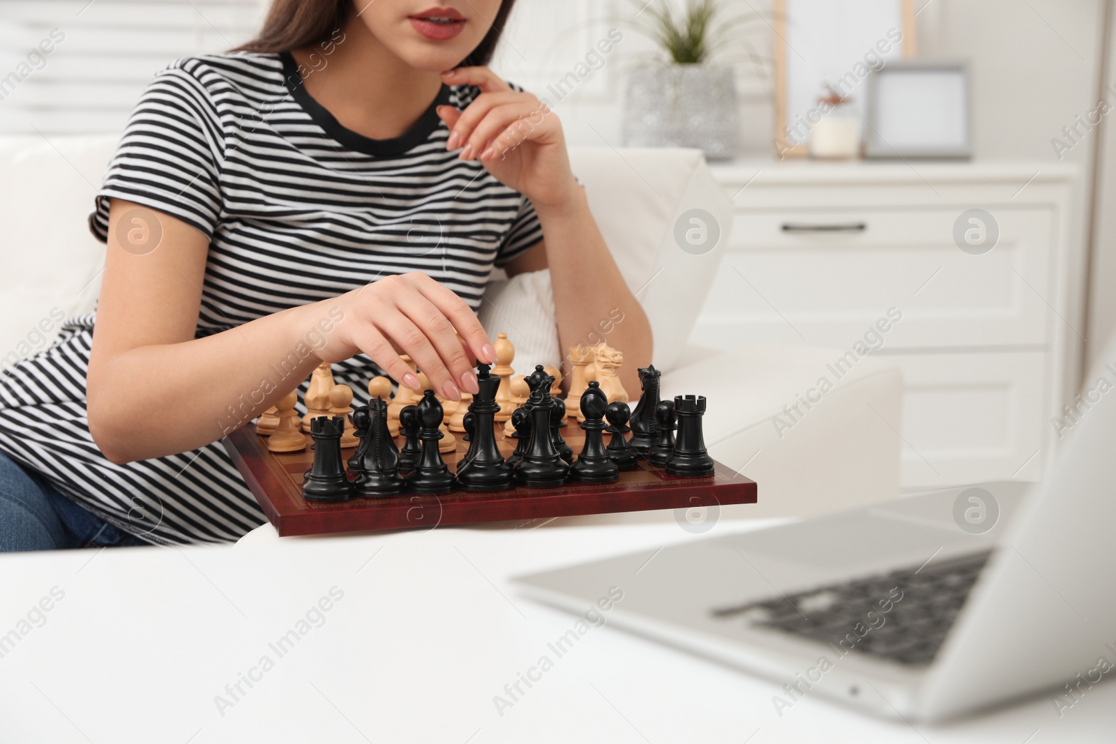 Photo of Woman playing chess with partner through online video chat at home, closeup