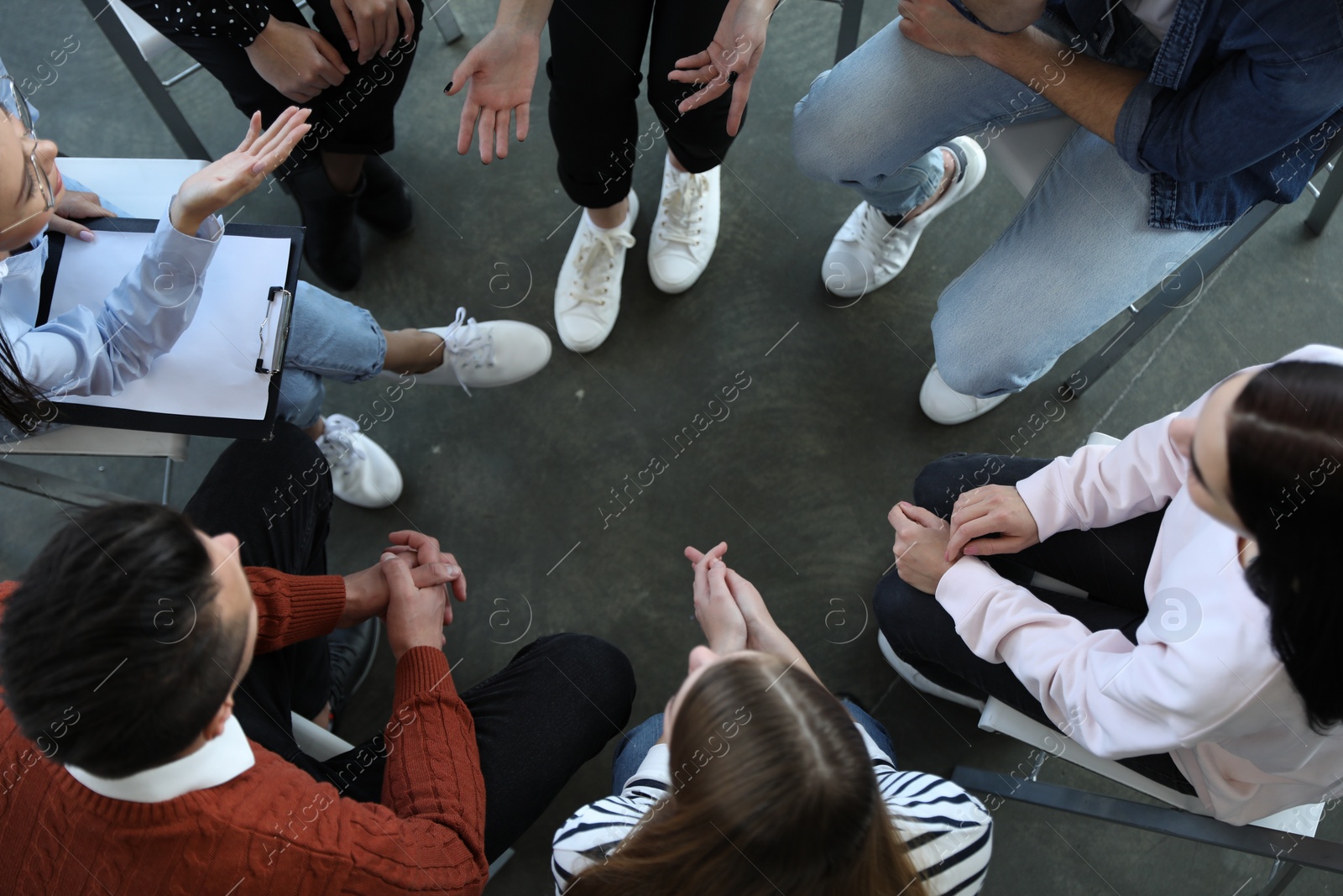 Photo of Psychotherapist working with patients in group therapy session, top view