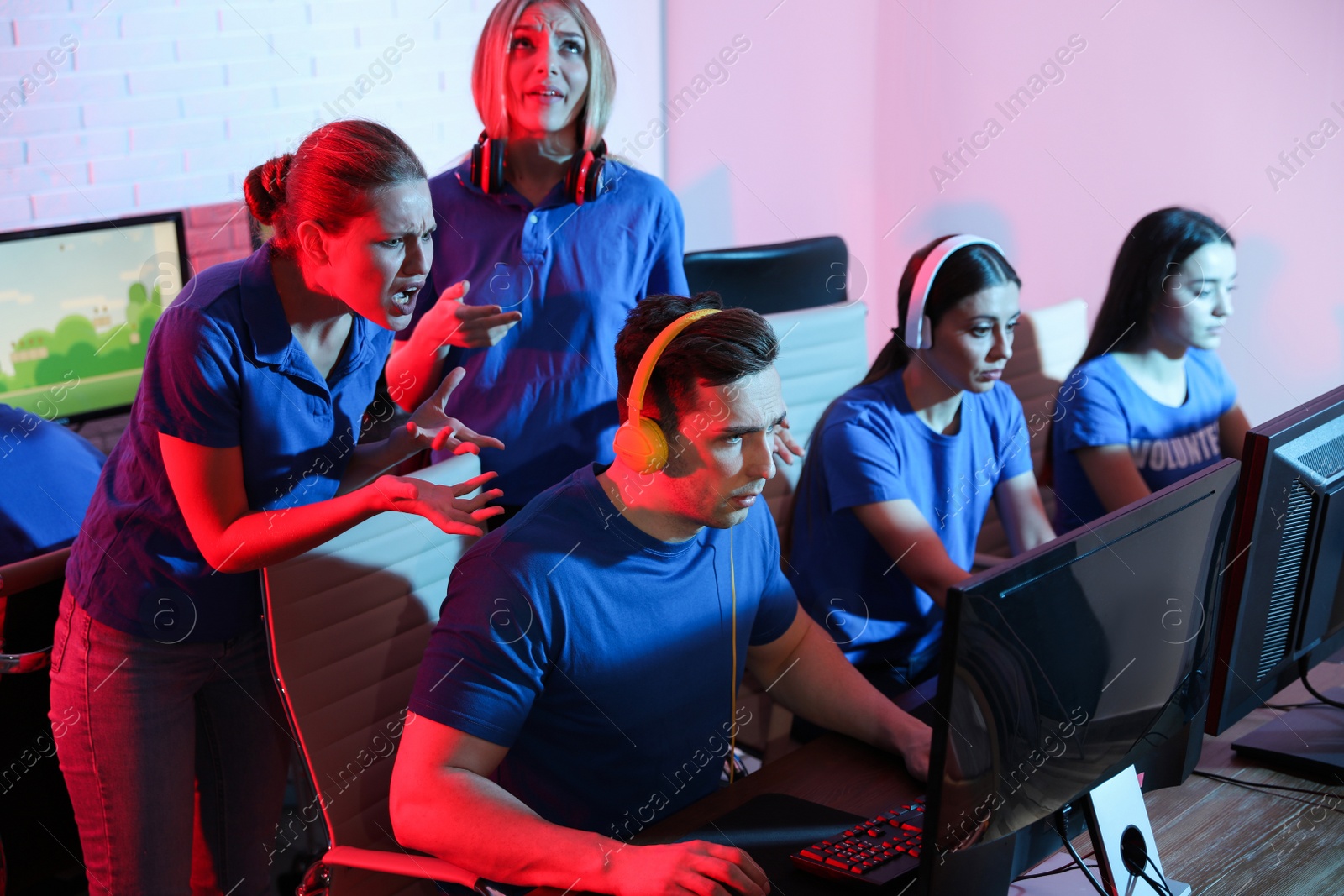 Photo of Young people playing video games on computers indoors. Esports tournament