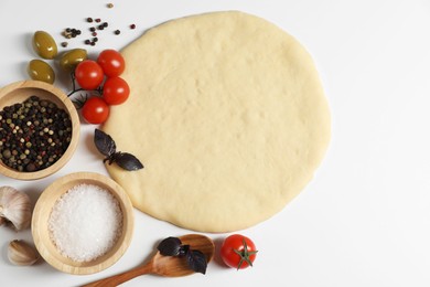 Fresh pizza dough and products on white background, flat lay. Space for text