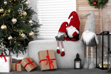 Photo of Cute Scandinavian gnomes, Christmas tree and gift boxes in room