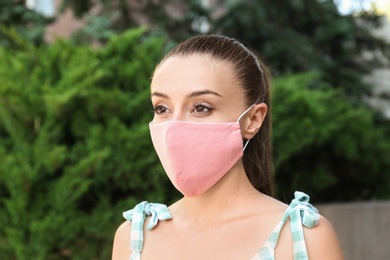 Photo of Woman wearing handmade cloth mask outdoors. Personal protective equipment during COVID-19 pandemic