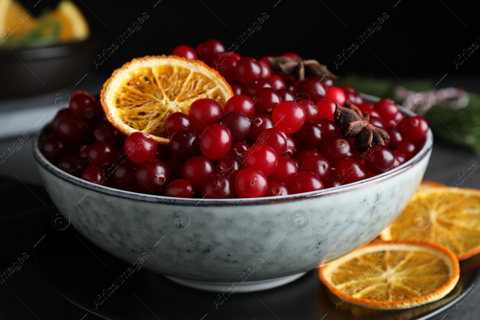 Photo of Fresh ripe cranberries, spices and orange slices on grey table, closeup