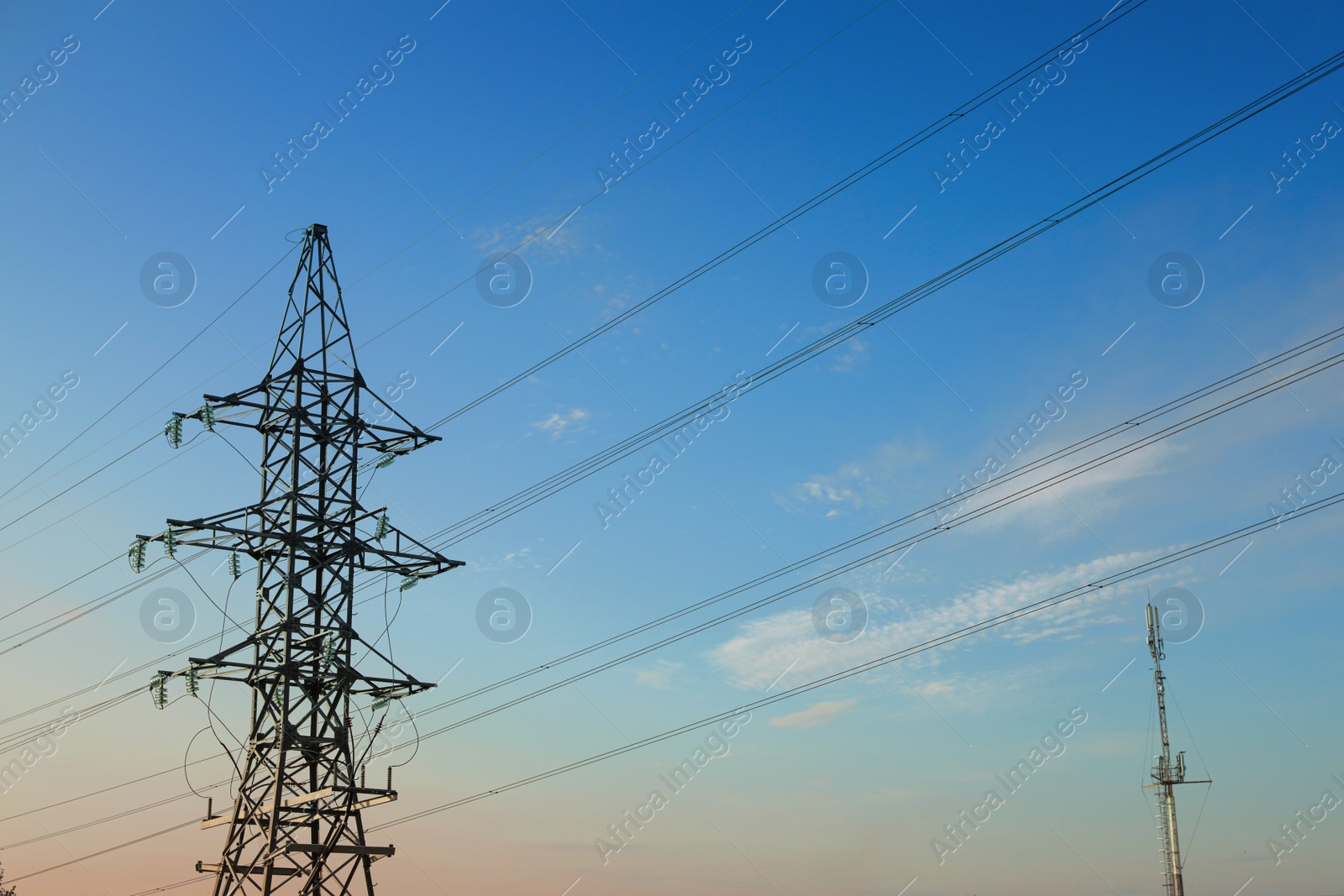 Photo of High voltage tower against blue sky on sunny day