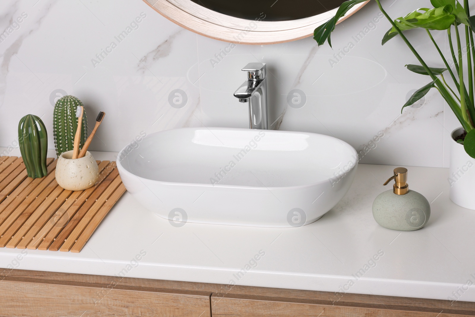 Photo of Stylish vessel sink on light countertop in modern bathroom