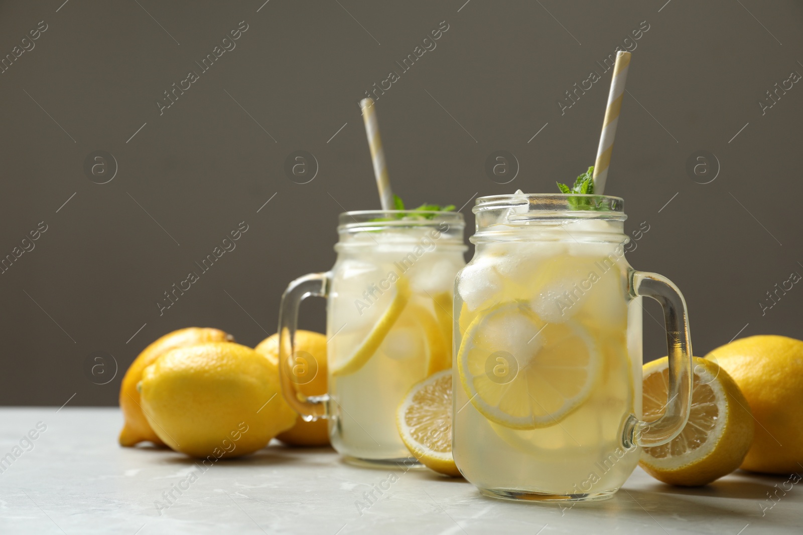 Photo of Natural lemonade with mint and fresh fruits on light grey marble table, space for text. Summer refreshing drink