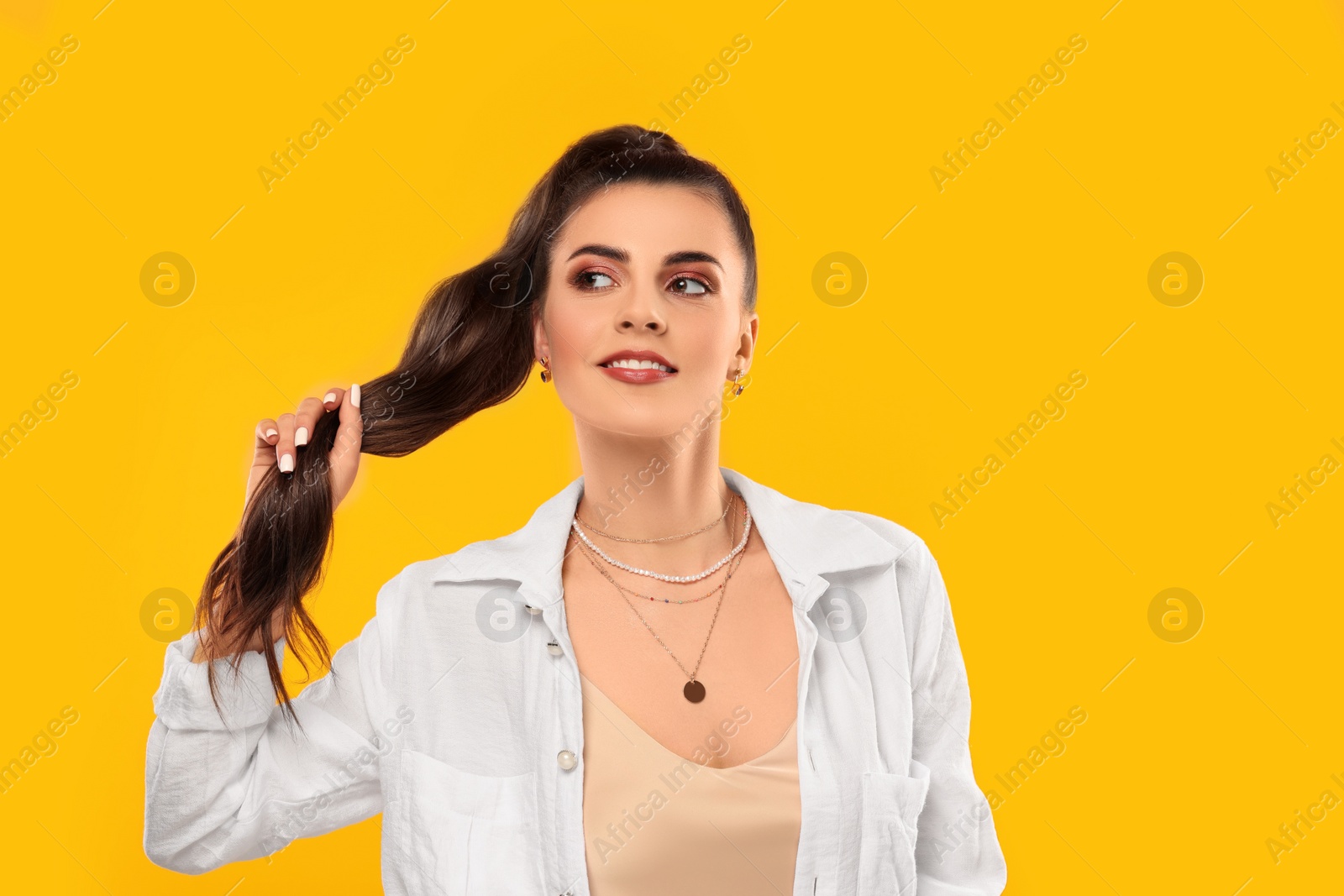 Photo of Beautiful woman with elegant jewelry on orange background