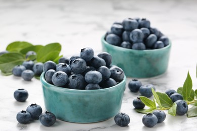Tasty fresh blueberries on white marble table, closeup