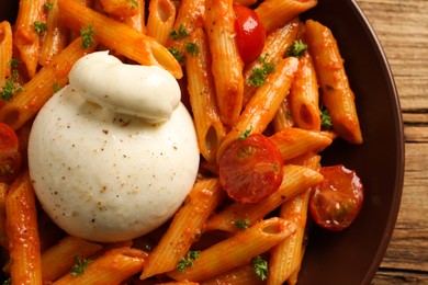 Photo of Delicious pasta with burrata cheese and tomatoes on table, top view