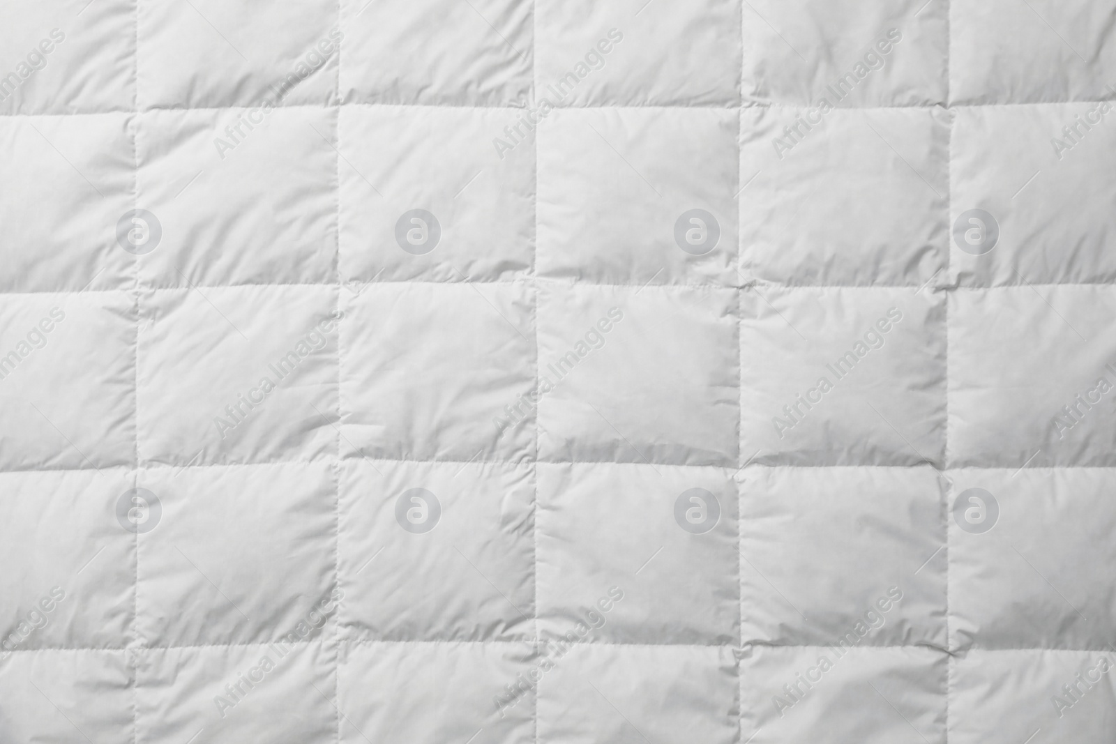 Photo of Soft quilted blanket as background, top view